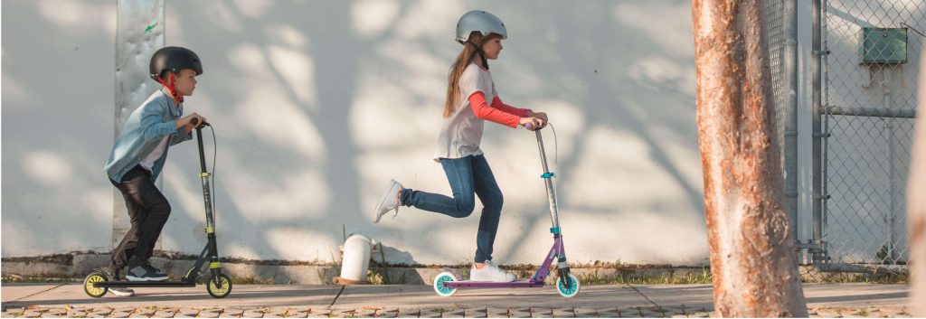 crianças andando de patinete
