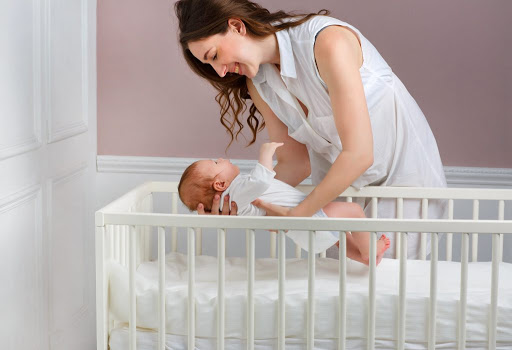 mãe colocando o bebê para dormir