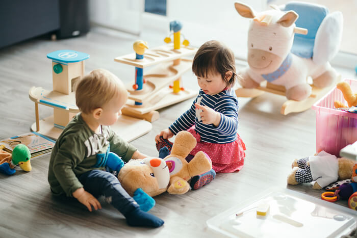 crianças brincando com ursinho de pelúcia