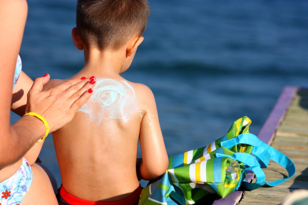 mãe com filho  melhores protetores solares infantis