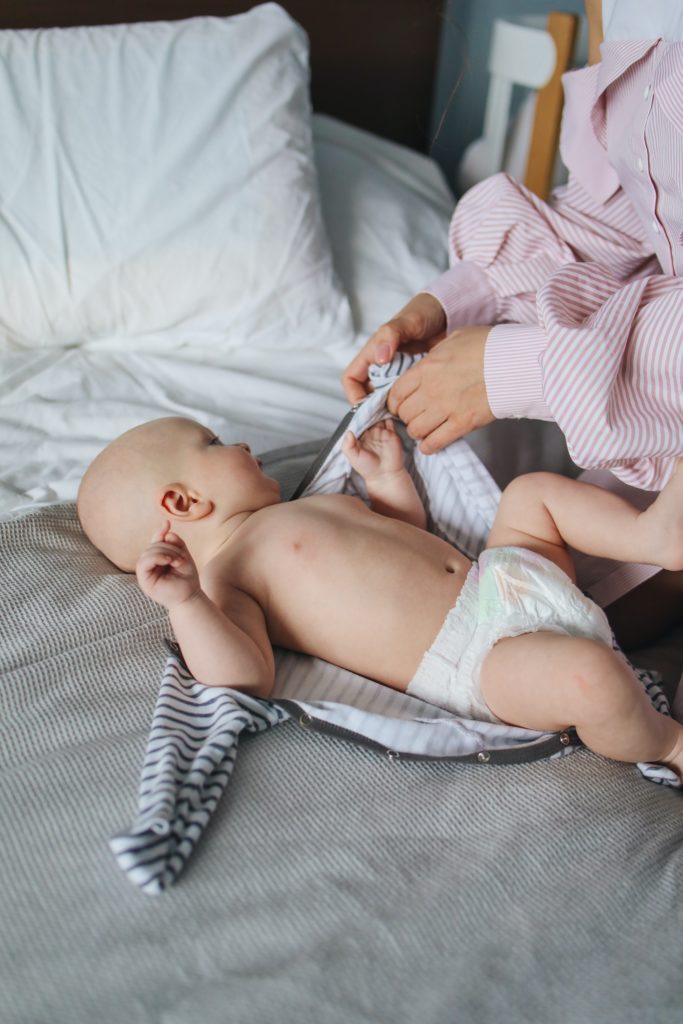 mãe trocando o bebê